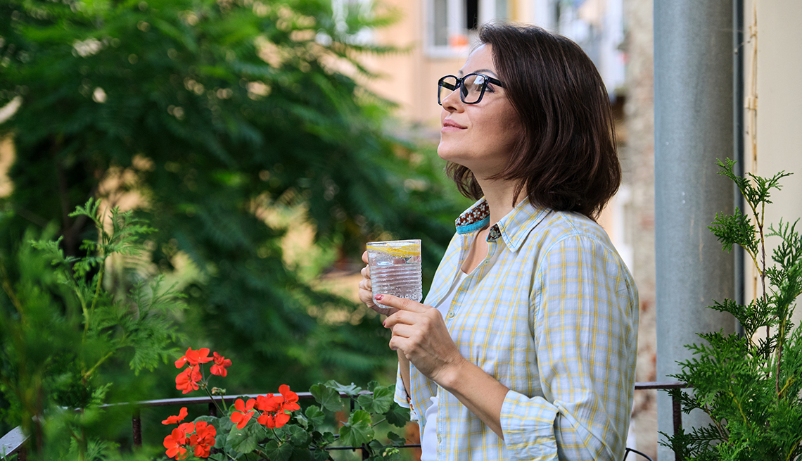 Woman standing outside relaxing woman drinking water with lemon