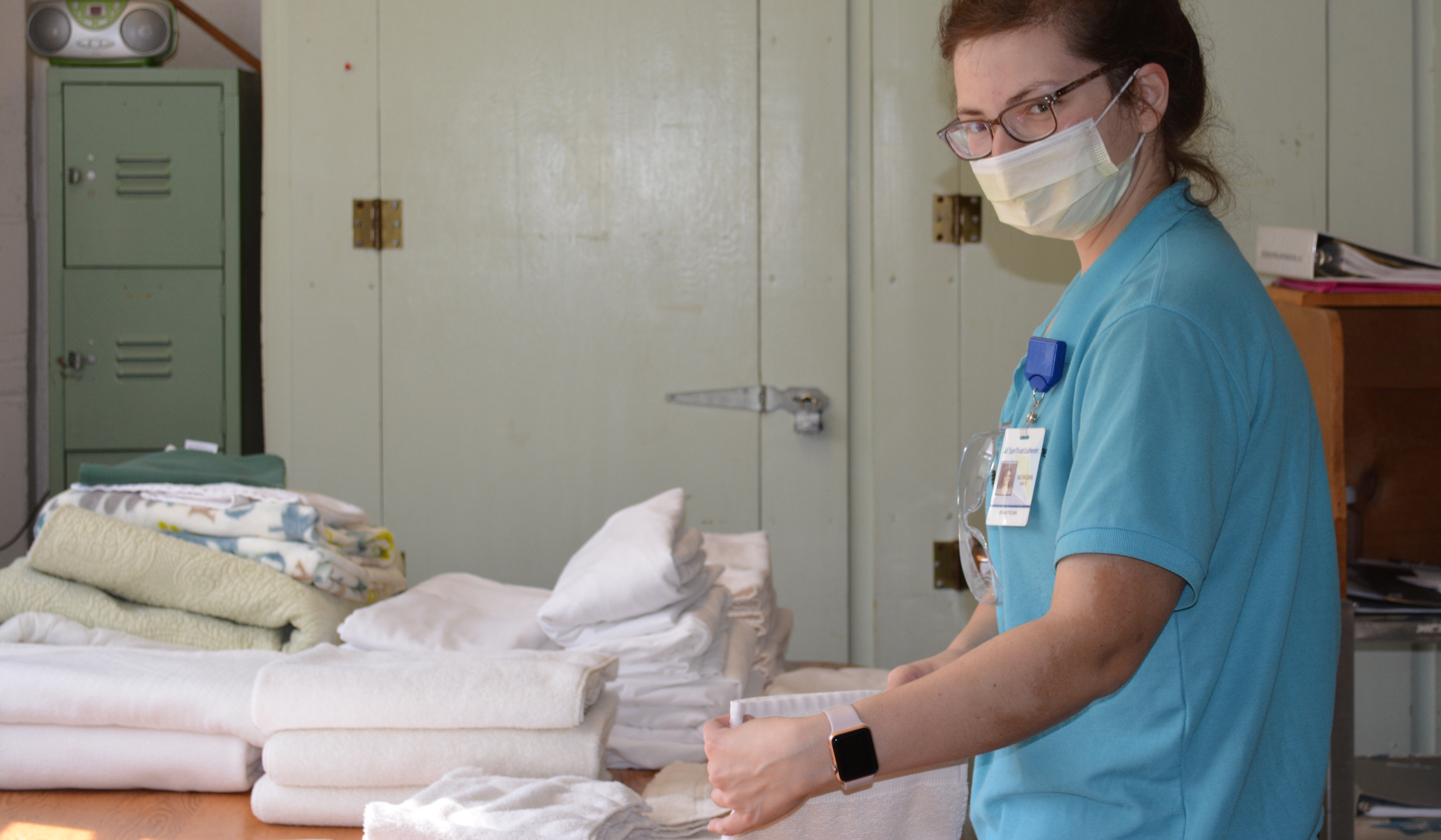 Un auxiliar de enfermería dobla la ropa en el centro luterano de cuidados a largo plazo de SpiriTrust.