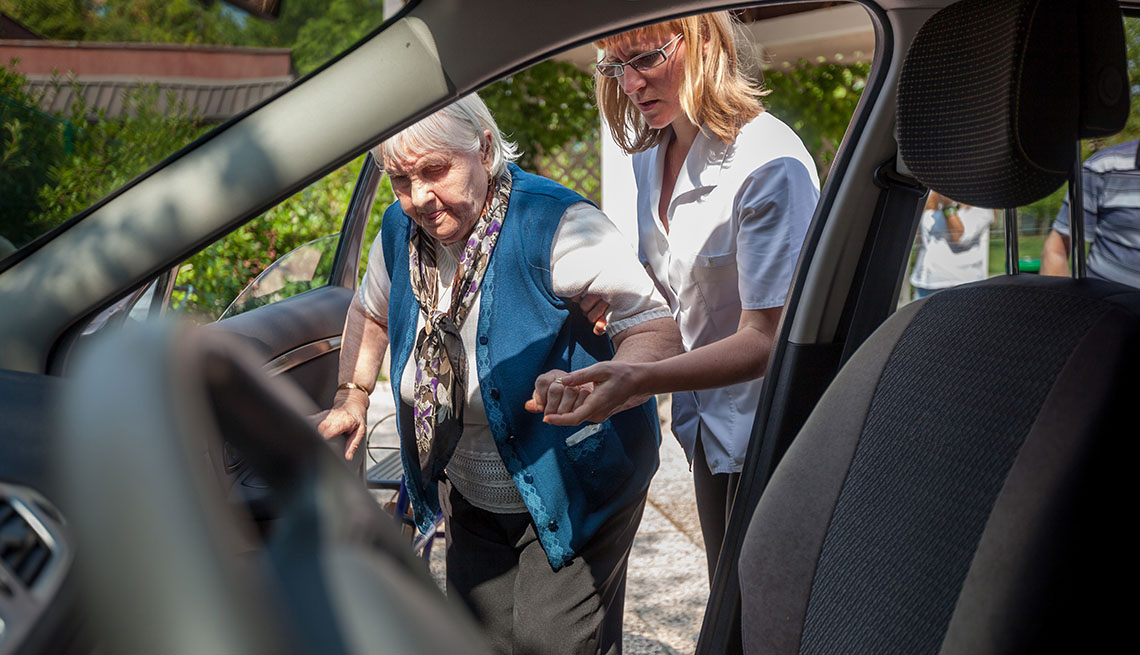 woman being helped into a car