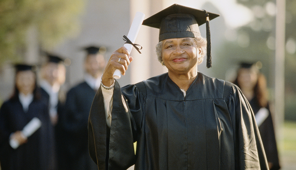 mature woman holding a diploma at graduation