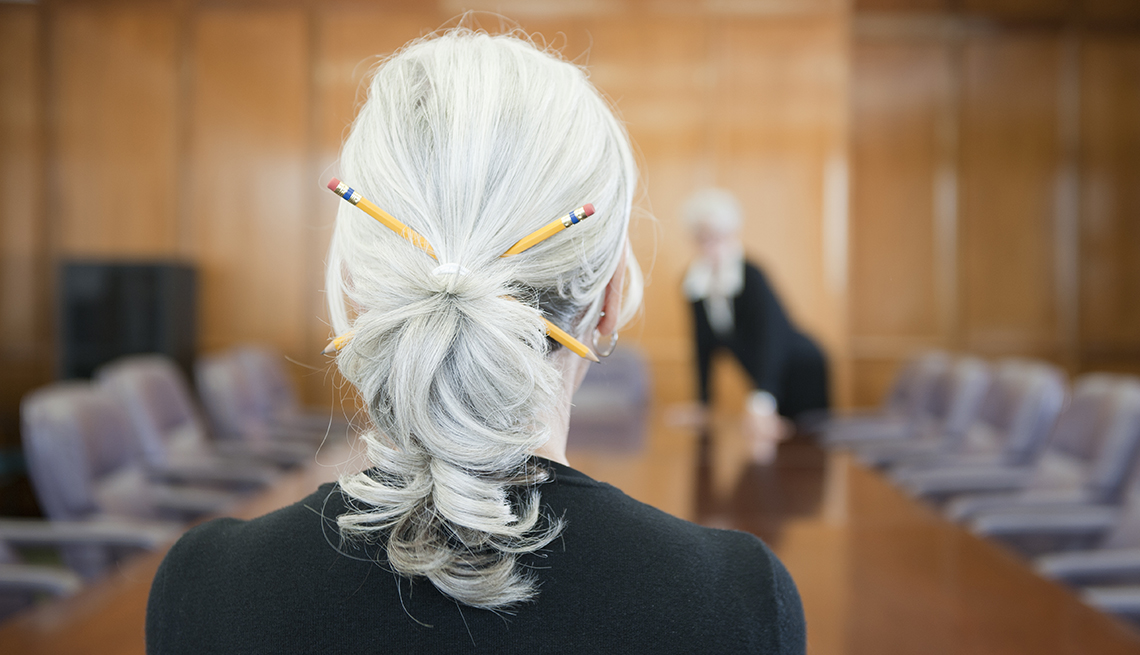 Woman with grey ponytail working in a conference room