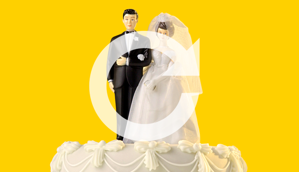 A man and wife wedding cake topper with a redo symbol overlaid on top