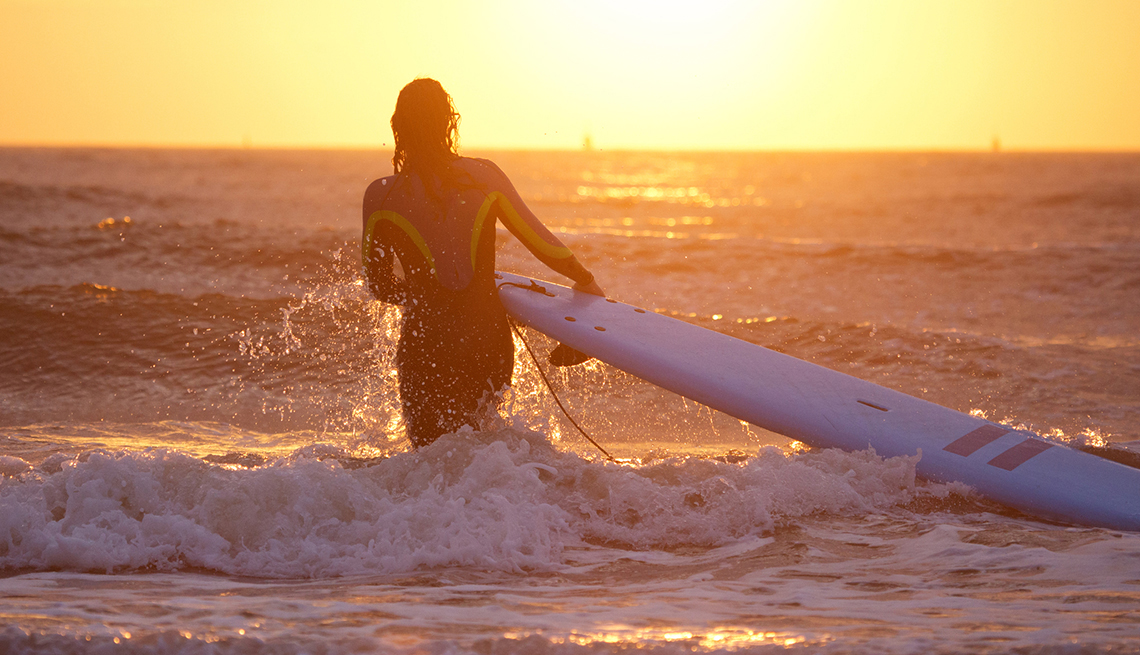 A female surfing alone at dusk