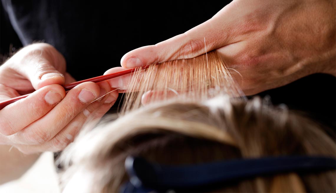 Estilista aplicando iluminaciones - Cuidado del cabello para hombres de 50 años o más