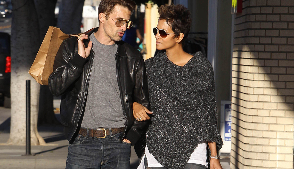 item 12 of Gallery image - Halle Berry wearing a gray poncho sweater, walks down a sidewalk with friend