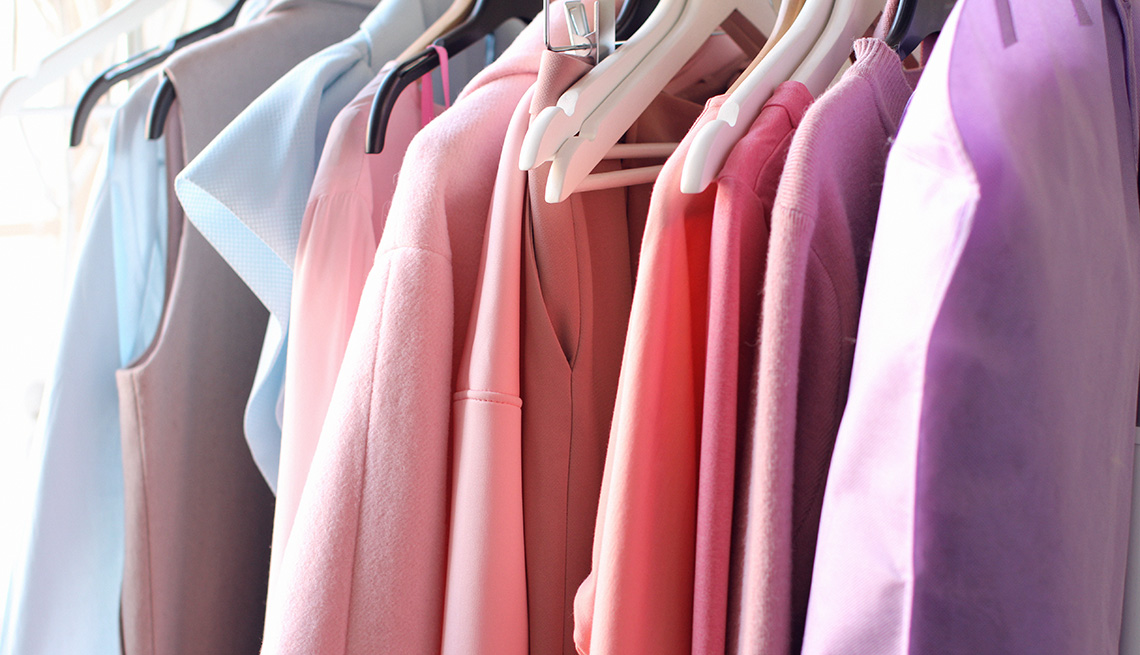 Various colored tops in a closet 