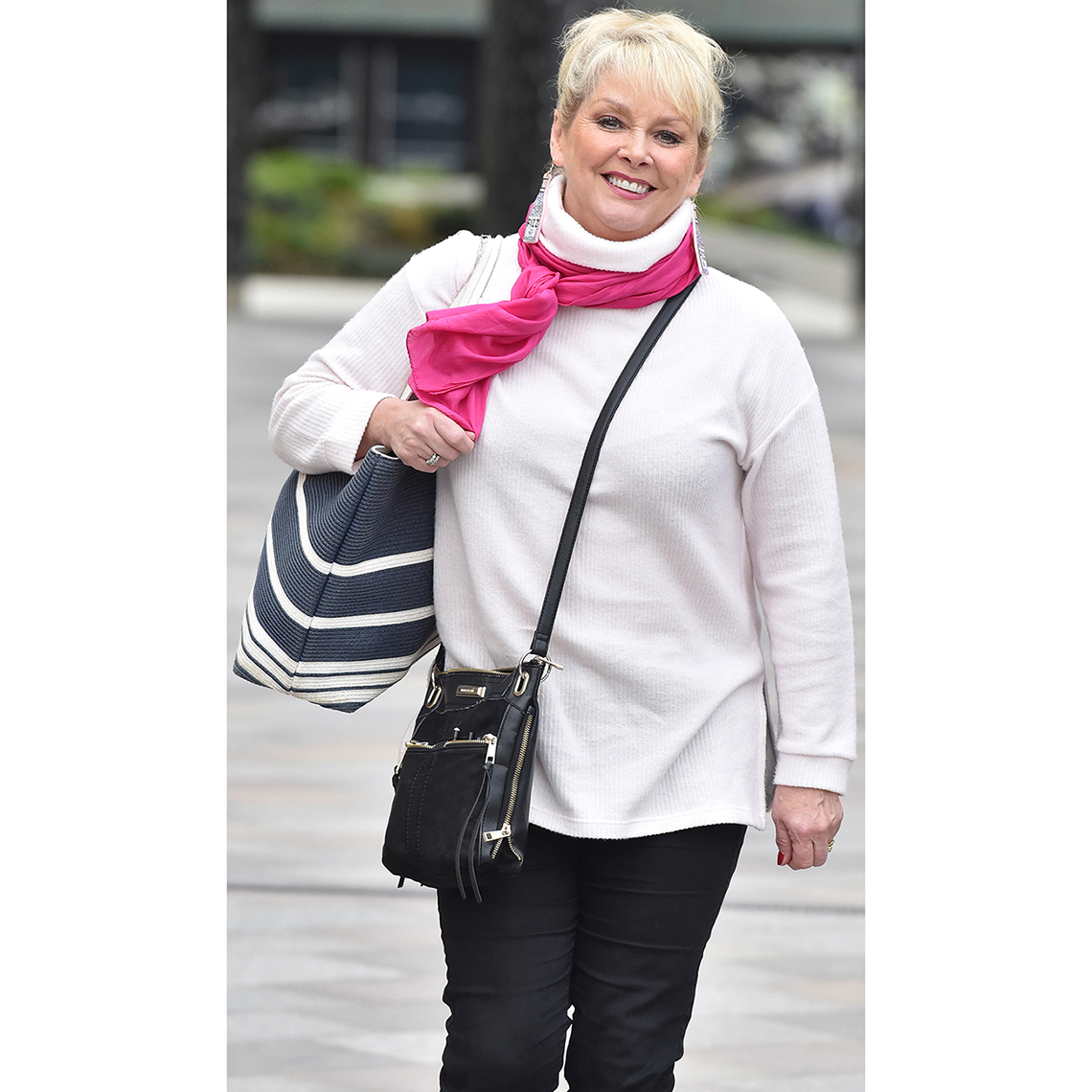 Cheryl Baker luce un bolso plano cruzado con compartimientos de cremallera 