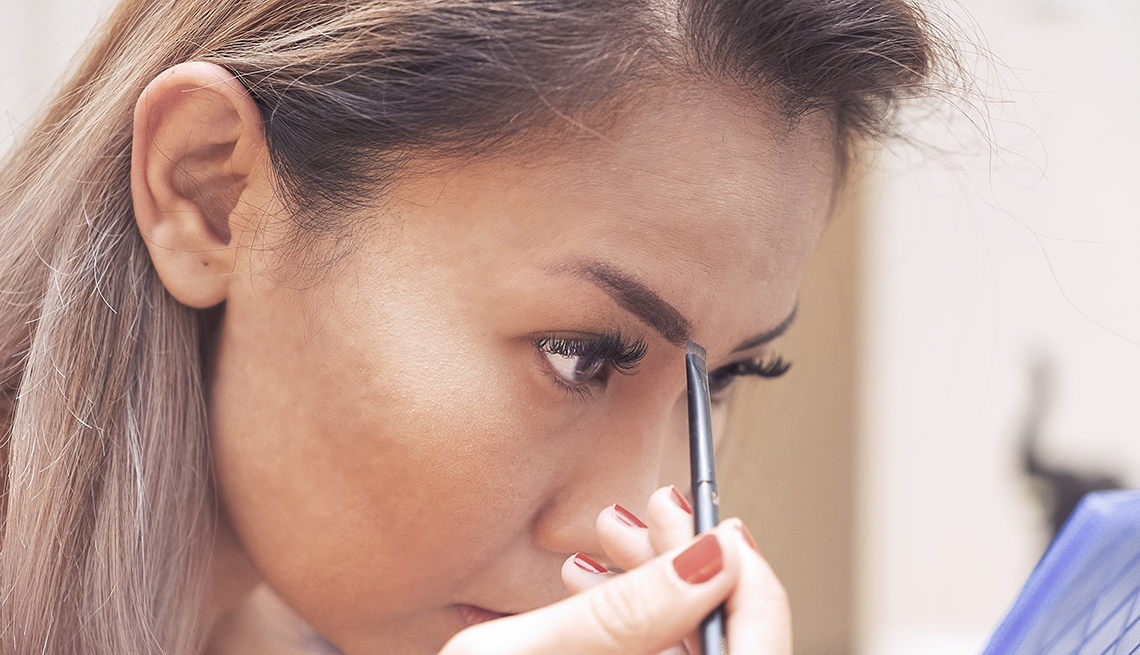 item 1 of Gallery image - A woman filling in her eyebrows with an eyebrow brush