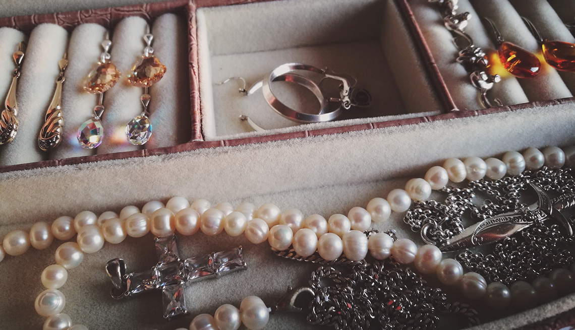 Pendientes, collares y otras joyas acomodadas en una caja.