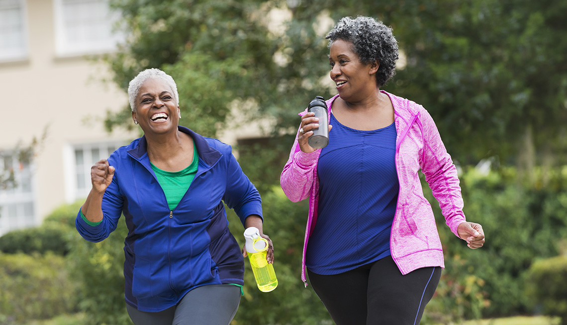 item 9 of Gallery image Two women taking a walk together while holding water bottles