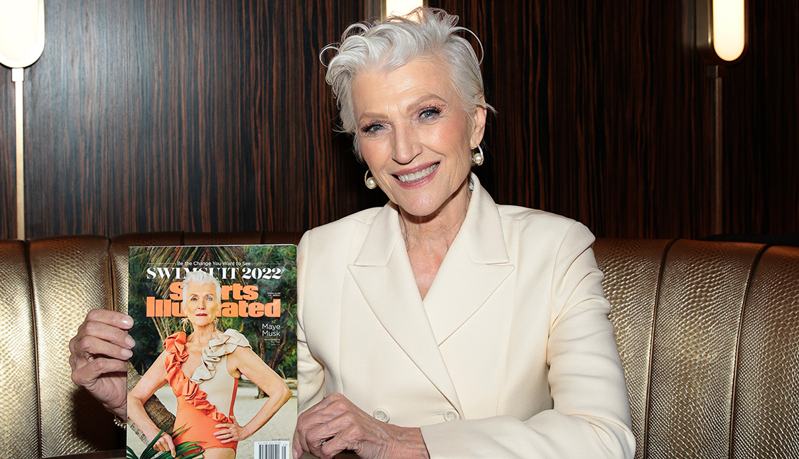 Maye Musk holds up her Sports Illustrated Swimsuit Issue cover at the launch of the 2022 Issue and Debut of Pay With Change with Sports Illustrated Swimsuit at Hard Rock Hotel New York
