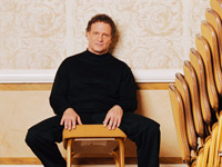 Albert Brooks with stacks of chairs.