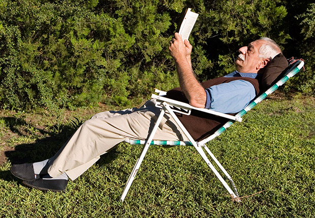 A man reads a book outside, 21 Great Novels It's Worth Finding Time to Read