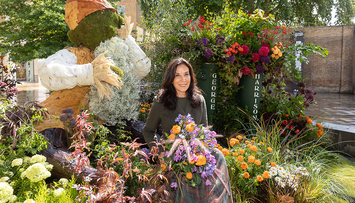 Olivia Harrison sits in a garden of flowers to recreate the iconic album cover for George Harrison’s All Things Must Pass