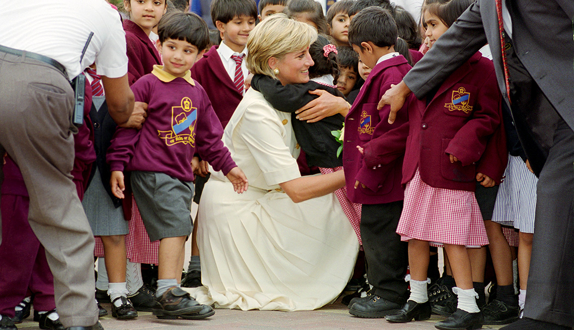item 11 of Gallery image - Diana, Princess of Wales crouching down to embrace a pupil at the Shri Swaminarayan Mandir in Neasden 