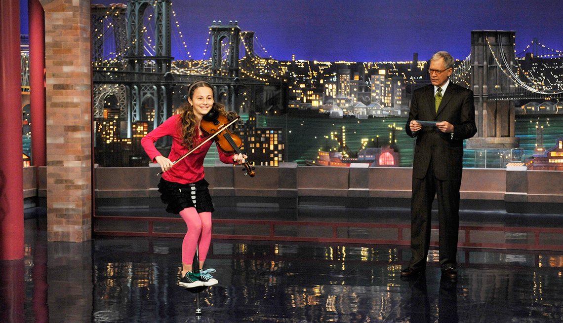 Dea Devlin jumps on a pogo stick and plays violin during Stupid Human Tricks on the Late Show with David Letterman