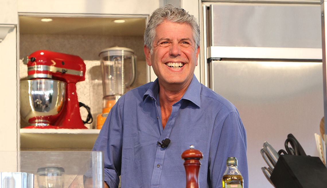 item 14 of Gallery image - Anthony Bourdain smiles in a kitchen. Blender, mixer, pepper and olive oil among the items in the kitchen.