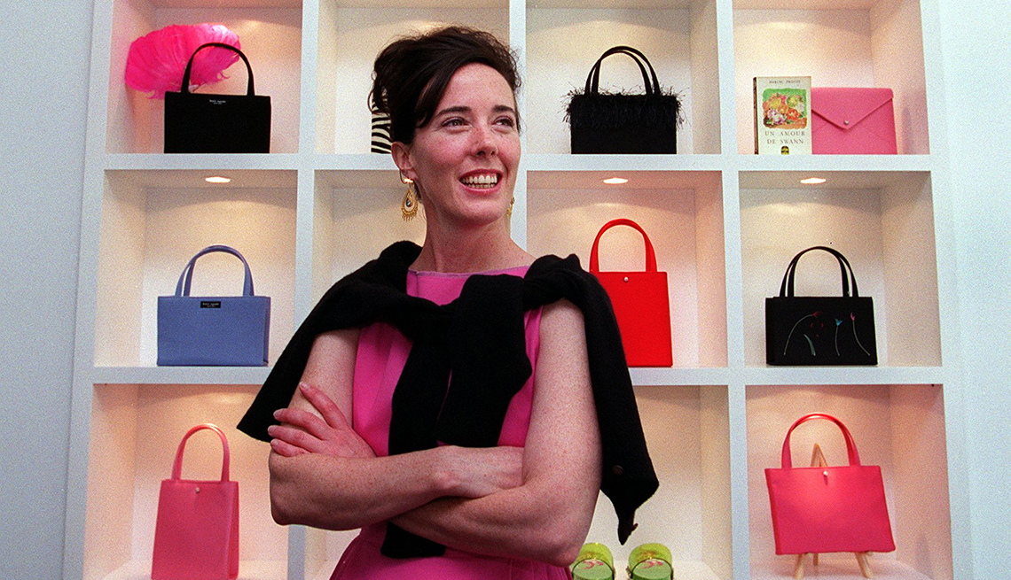 item 15 of Gallery image - Kate Spade standing in front of colorful handbags.