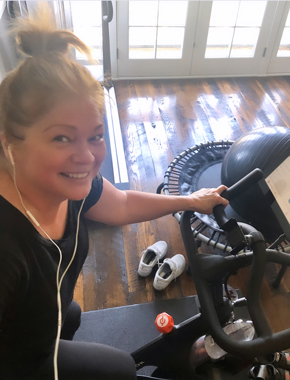 Valerie Bertinelli takes a selfie of herself using an exercise bike inside her home