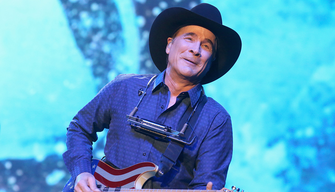item 2 of Gallery image - Clint Black playing his patriotic flag themed guitar in concert at the HEB Center in Cedar Park Texas