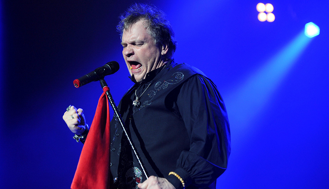 Meatloaf holds onto the microphone stand while performing in concert at Wembley Arena in London