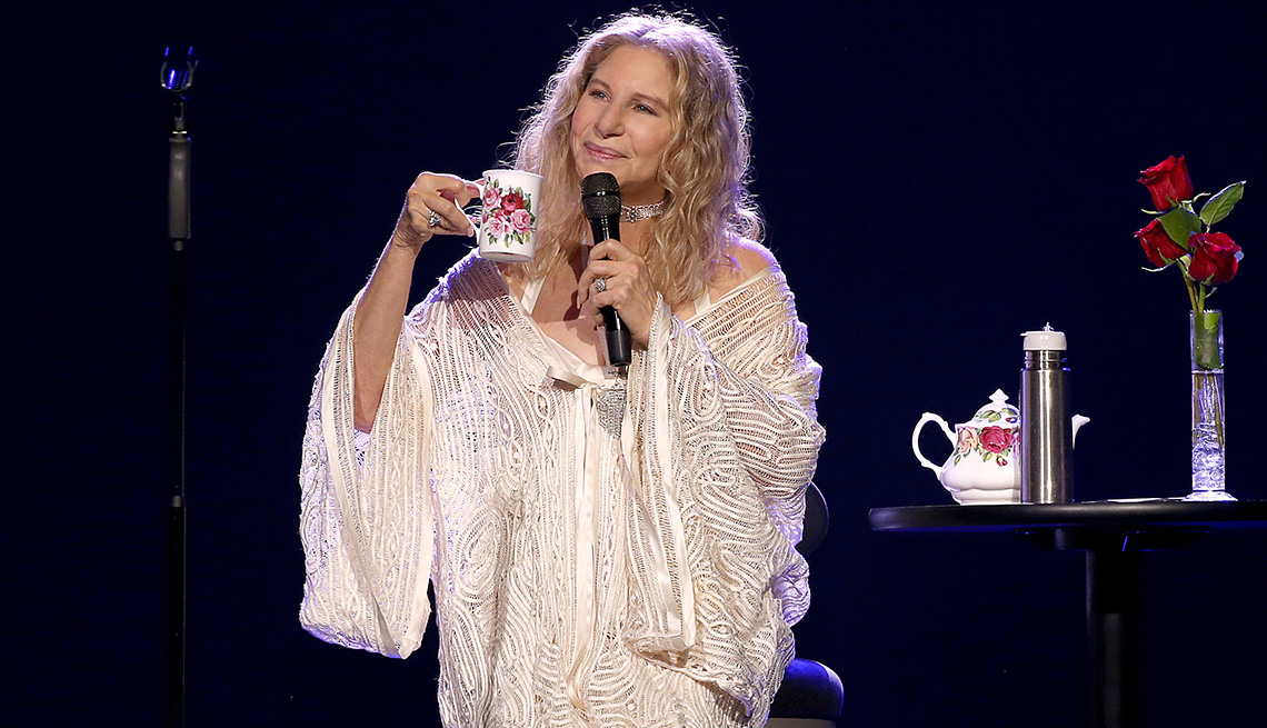 item 7 of Gallery image - Barbra Streisand holds a cup and a microphone as she performs onstage at Madison Square Garden