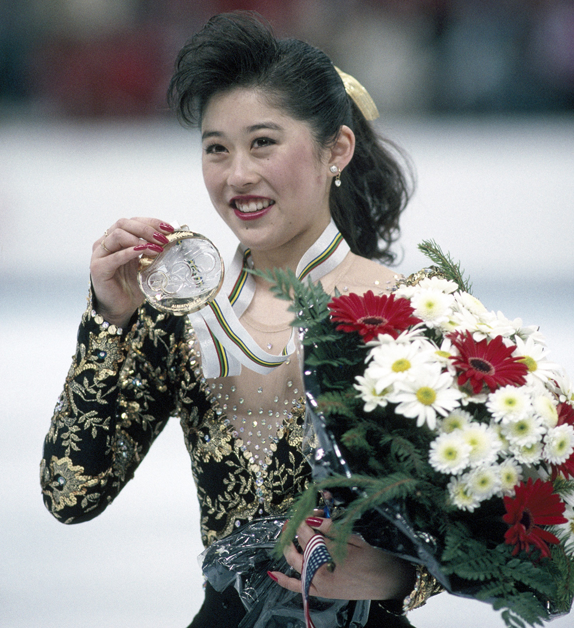 Kristi Yamaguchi holds up her gold medal after her performance in the ladies skating event during the 1992 Winter Olympic Games in Albertville France