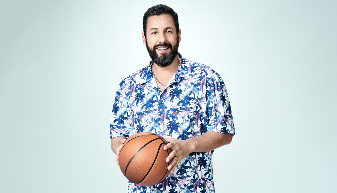 Adam Sandler poses with a basketball in his hands
