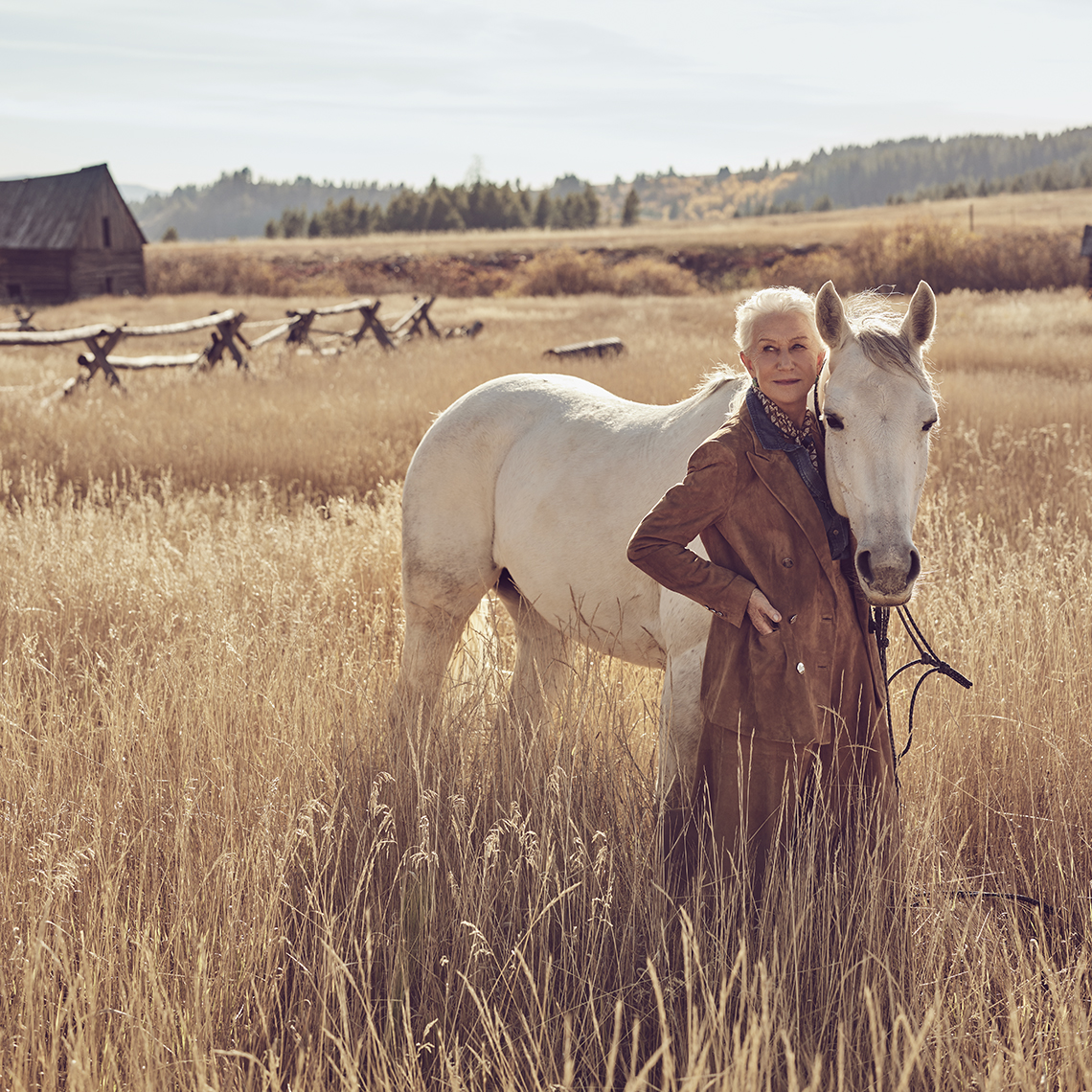 Helen Mirren posa junto a un caballo blanco en un campo de Montana
