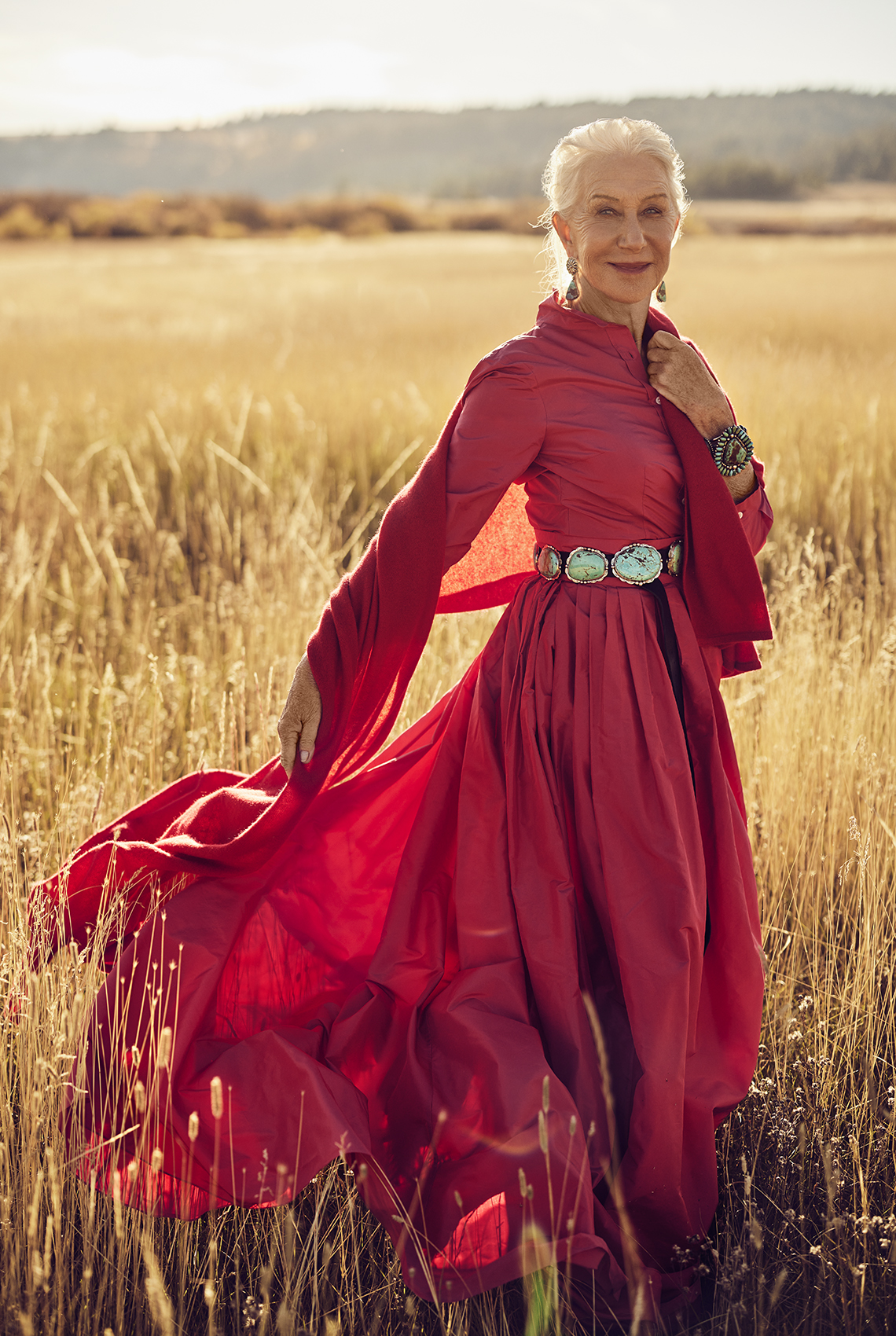 Helen Mirrenen un vestido rojo en un campo en Montana