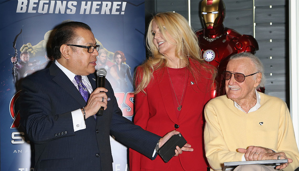 Publicist Jerry Olivarez holds microphone as  J C Lee and Stan Lee look on