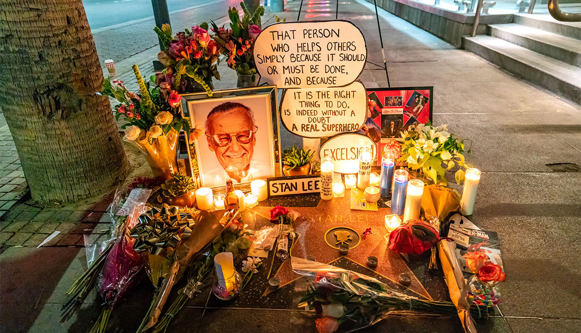 candles and flowers and picture of stan lee on sidewalk memorial 
