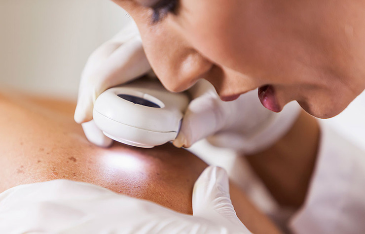 Dermatóloga viendo la piel de un paciente y los cuidados para mejorar la apariencia del rostro
