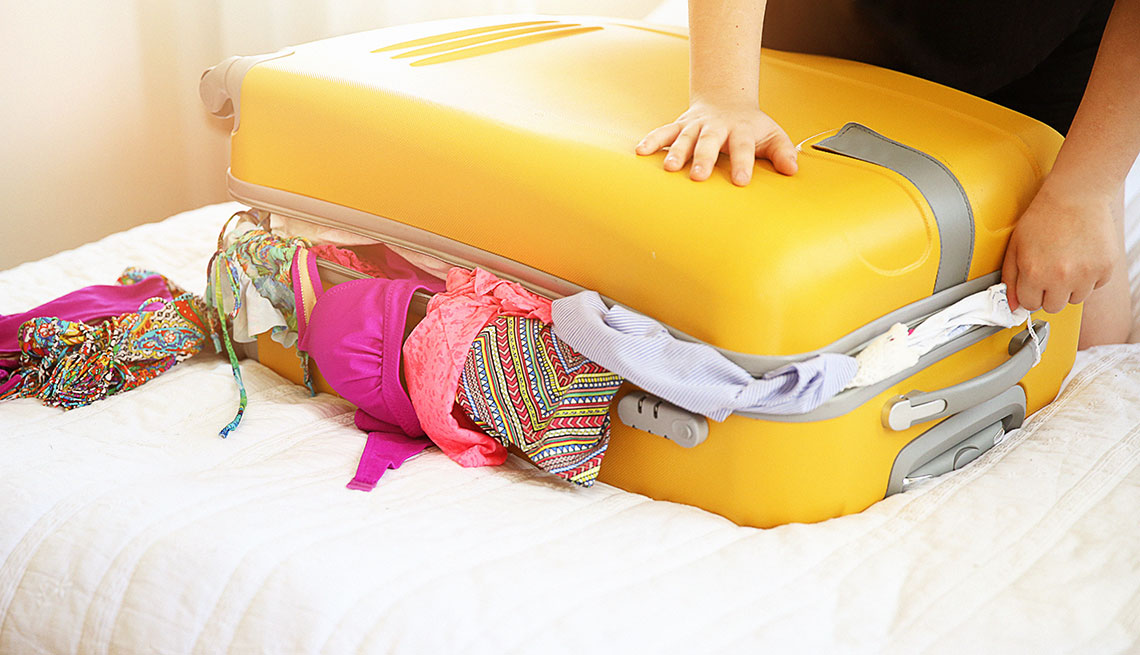 Woman packing a large suitcase 