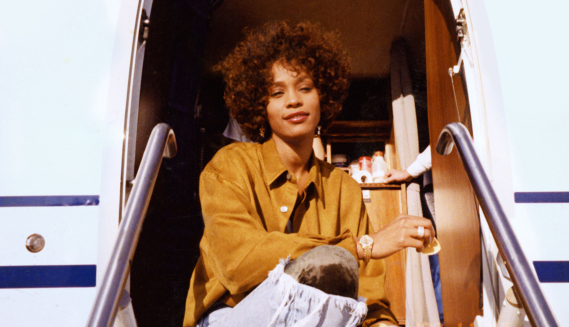 Whitney Houston sits on stairs of plane in a scene from the documentary 'Whitney'