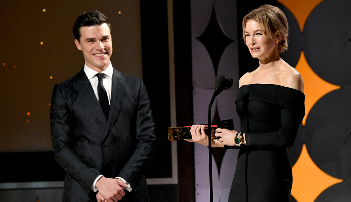 Finn Wittrock mira a Renee Zellweger mientras da su discurso después de recibir su premio como mejor actriz en los premios Movies for Grownups.