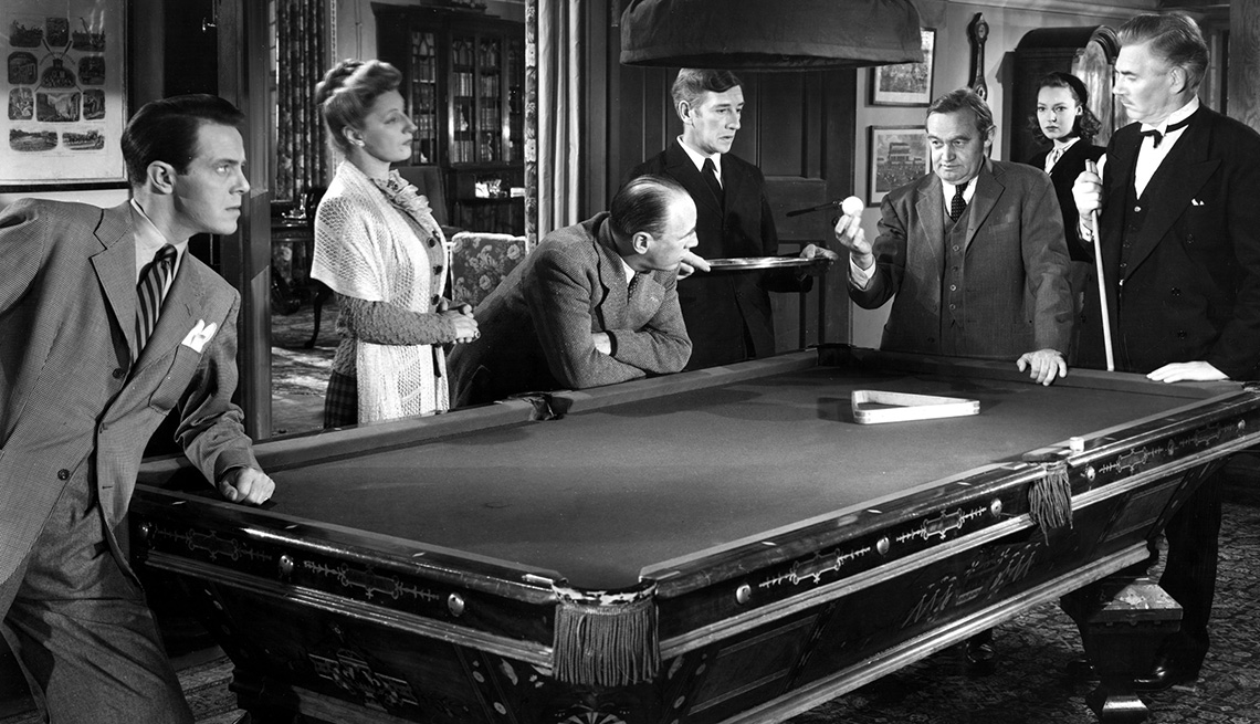 The cast of the 1945 film And Then There Were None standing around a pool table