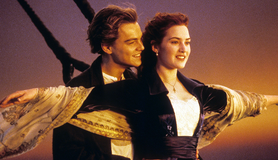 Leonardo DiCaprio stands next to Kate Winslet as she spreads her arms at the ship’s prow in the film Titanic