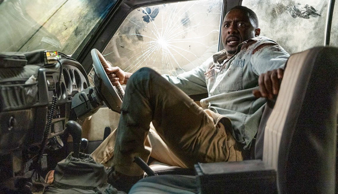 Idris Elba inside a vehicle with a concerned look on his face in the film Beast