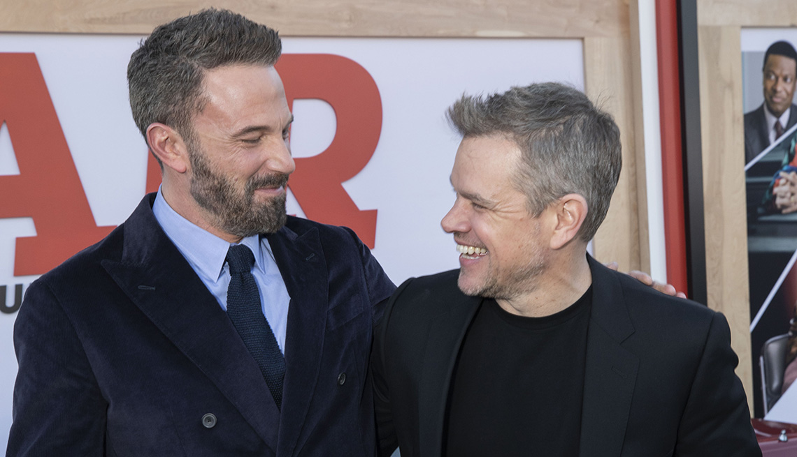 Ben Affleck and Matt Damon smile at each other while on the red carpet at the world premiere of the film Air in Los Angeles