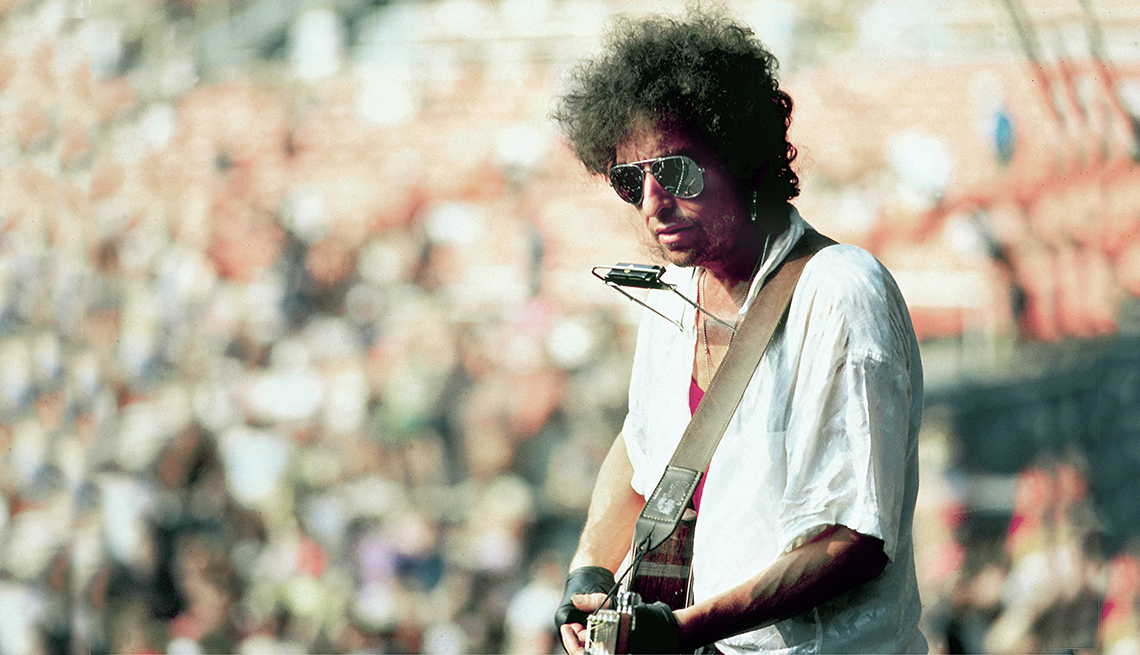 Bob Dylan en concierto al aire libre con su guitarra y armónica, qué tanto sabes del artista 