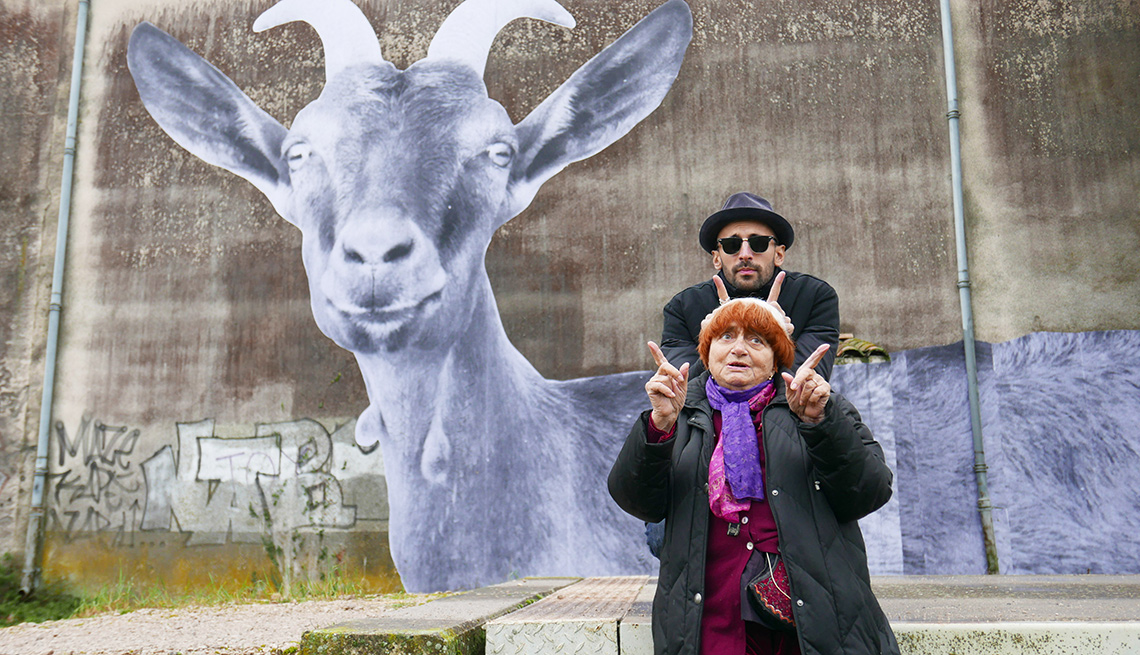 La cineasta Agnès Varda y el fotógrafo y muralista JR con sus dedos levantados en un recorrido por Francia en su documental, 'Faces Places'.