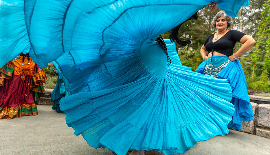 Mujer bailando y ondeando su falda larga color azul