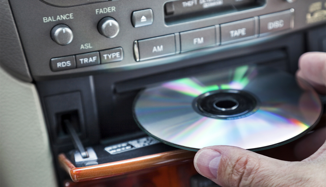Man inserting CD in car player
