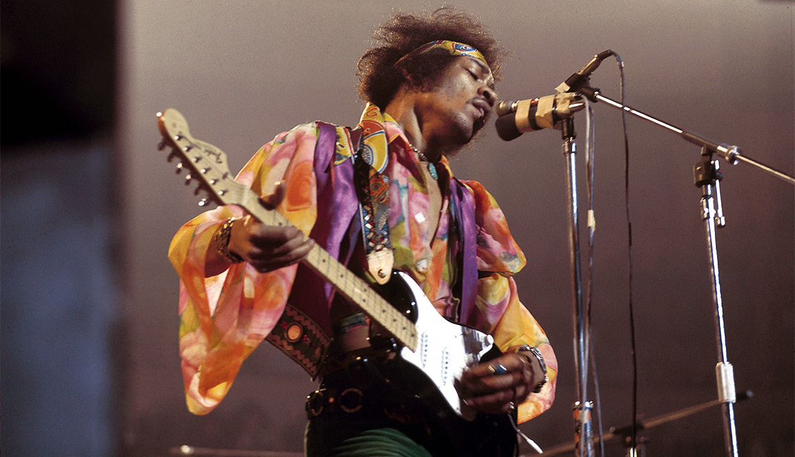 Jimi Hendrix performing live onstage, playing black Fender Stratocaster guitar