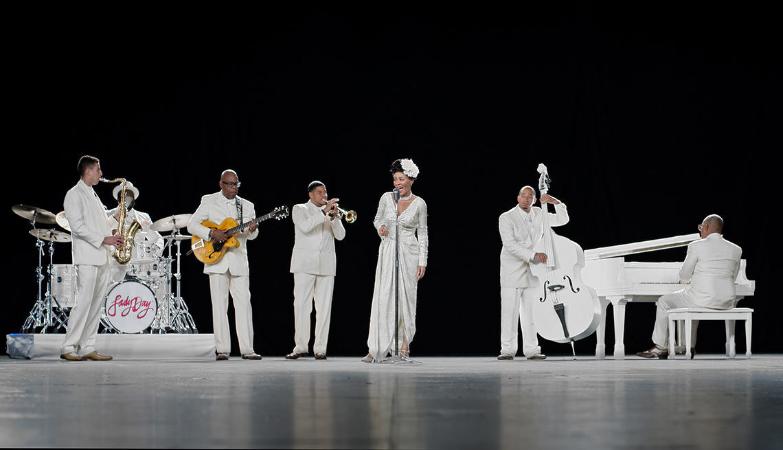 band on stage all dressed in white playing instuments