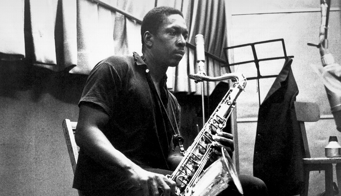 Photograph of John Coltrane recording in the studio around 1958.