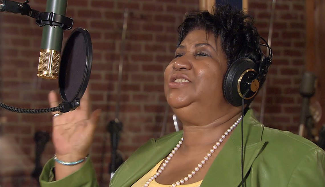 Aretha Franklin singing in front of a microphone.