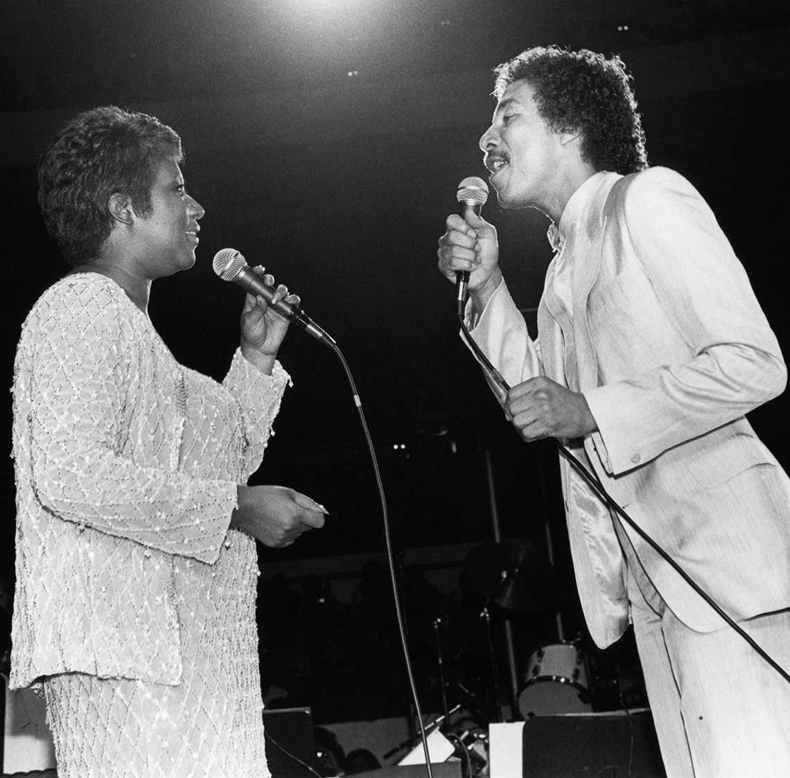 Aretha Franklin cantando con Smokey Robinson en un escenario.