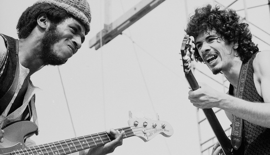 Carlos Santana (right) and bassist David Brown perform with the other members of Santana at Woodstock in 1969.